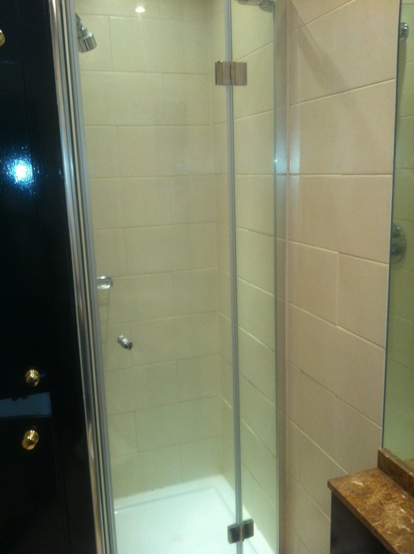 Frameless glass shower enclosure with chrome fittings in Tooting